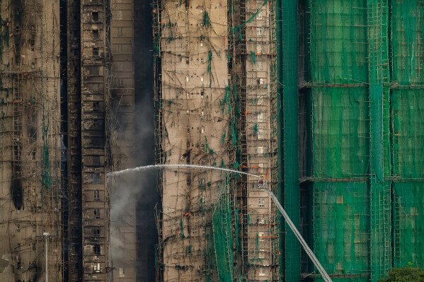 Firefighters work to extinguish a fire which broke out Wednesday at Wang Fuk Court, a residential estate in the Tai Po district of Hong Kong's New Territories, Thursday, Nov. 27, 2025. (AP Photo/Chan Long Hei)